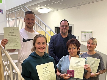 Gruppenbild mit Fachberater Fabian Spies (hinten rechts) und den pädagischen Fachkräften, die stolz ihre Zertifikate in den Händen halten